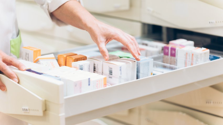 Close up of pharmacist hand taking meds from drawer