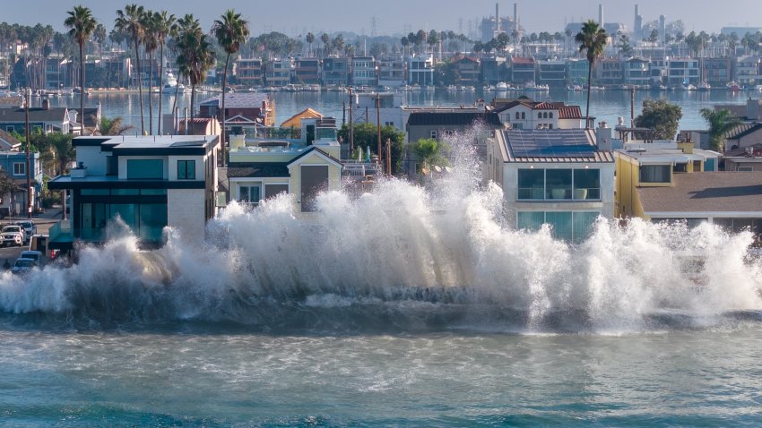A wave crashes against seawall boards and damaged beachfront homes along the Long Beach Peninsula as a combination of high tide and high surf generated by distant Hurricane Rachel impacts the Southern California coast.